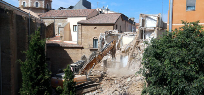 Una excavadora enderroca un edifici al carrer Cavallers de Lleida, a la vora del Parador.