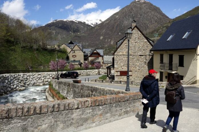 una parella passejant per un pont per damunt del Garona a Tredós, a Naut Aran